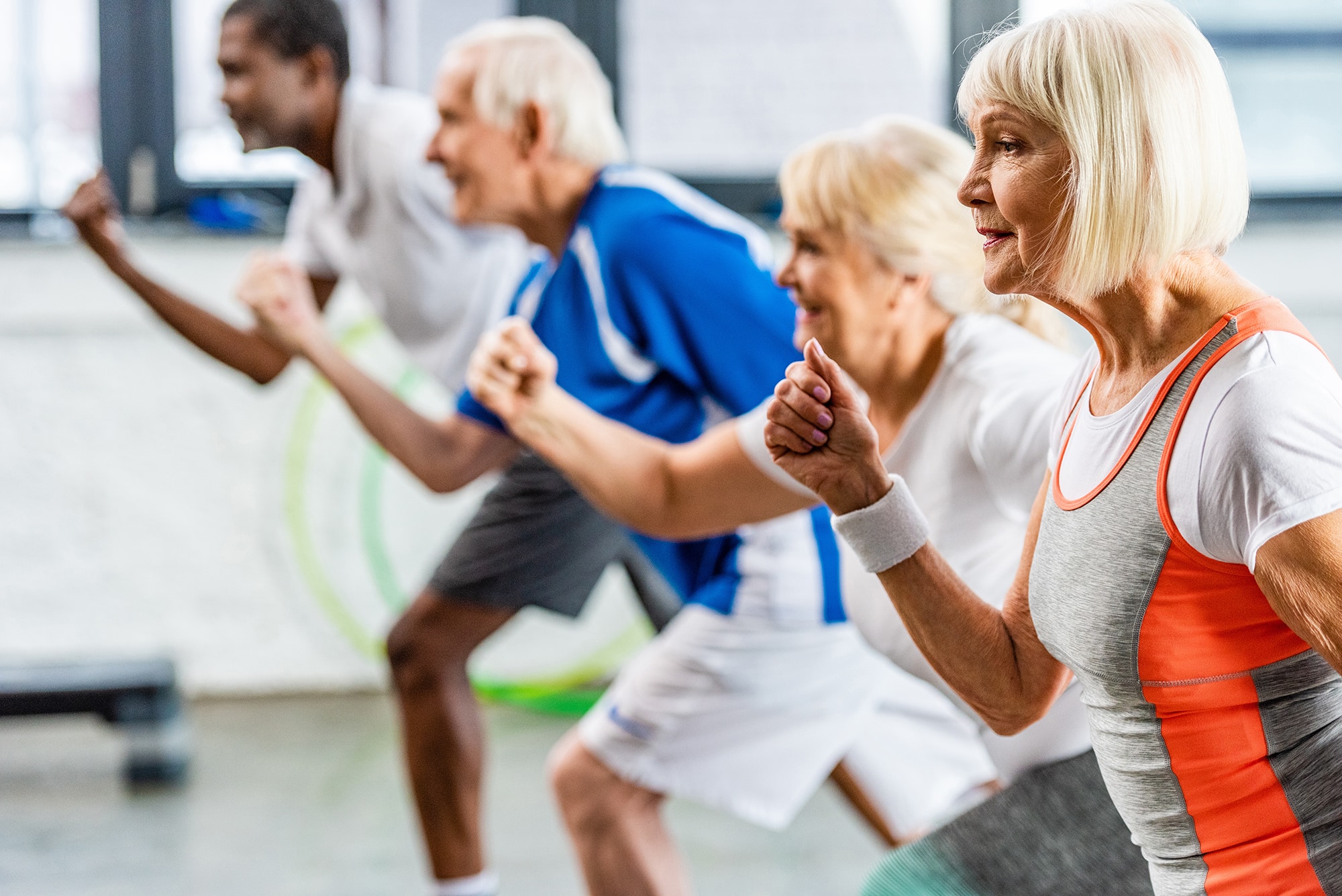 selective focus of senior sportswoman exercising with friends at