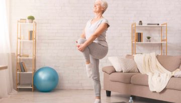 Active senior woman doing legs exercise at home