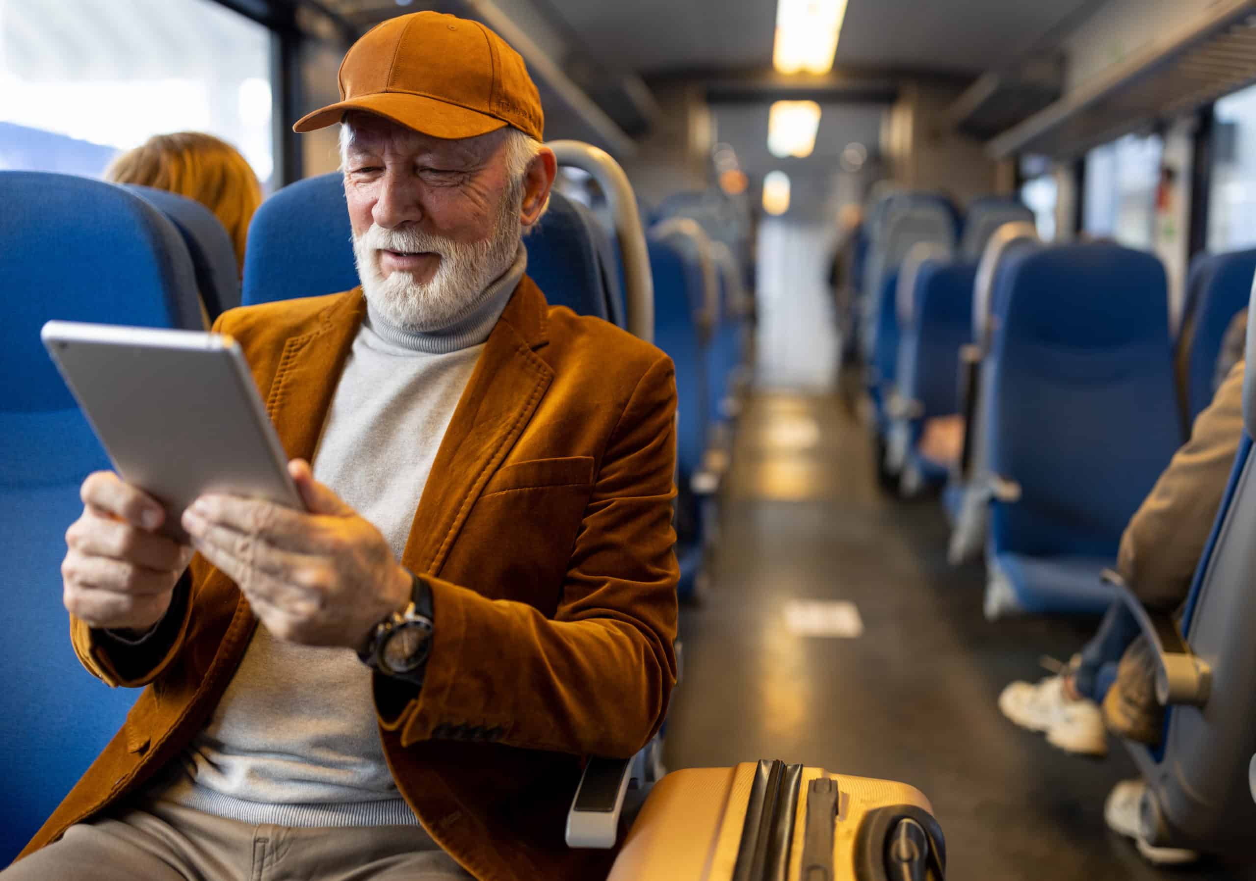 Senior man reading on tablet in train